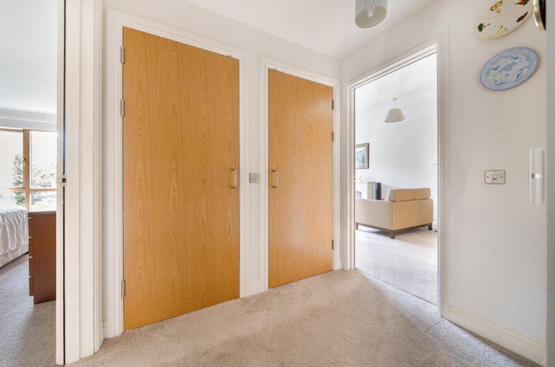 Hallway with storage cupboards and ut...