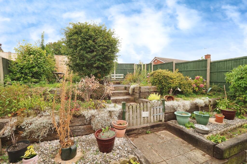 Well loved garden with layered beds and seating area