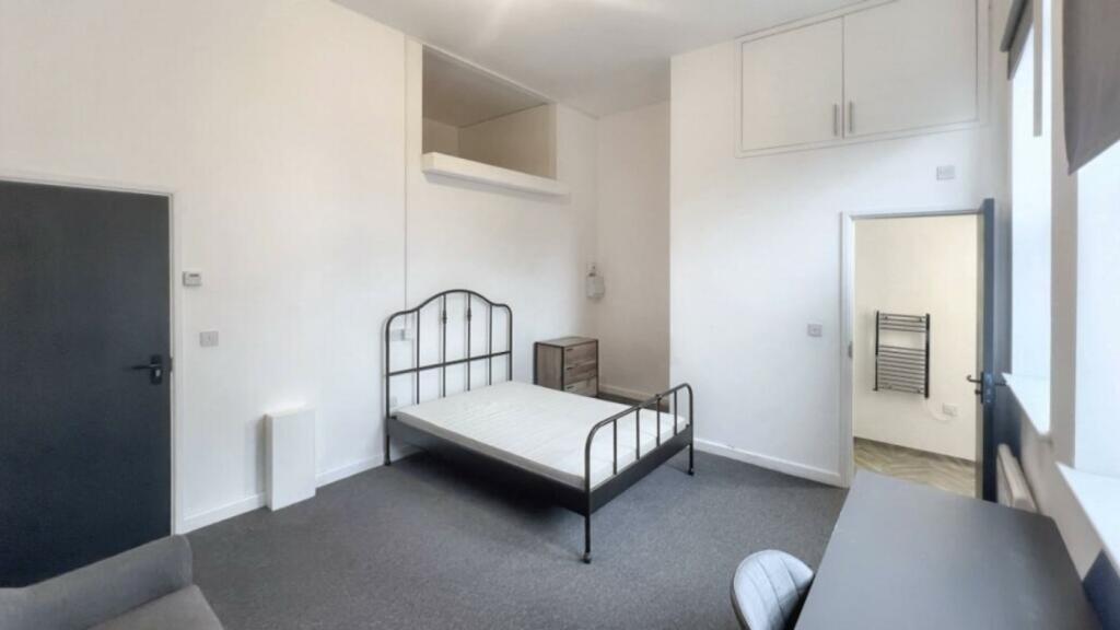 A spacious and inviting double bedroom with mod...