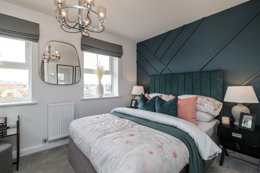 Double bedroom with blue panelled wall and two windows